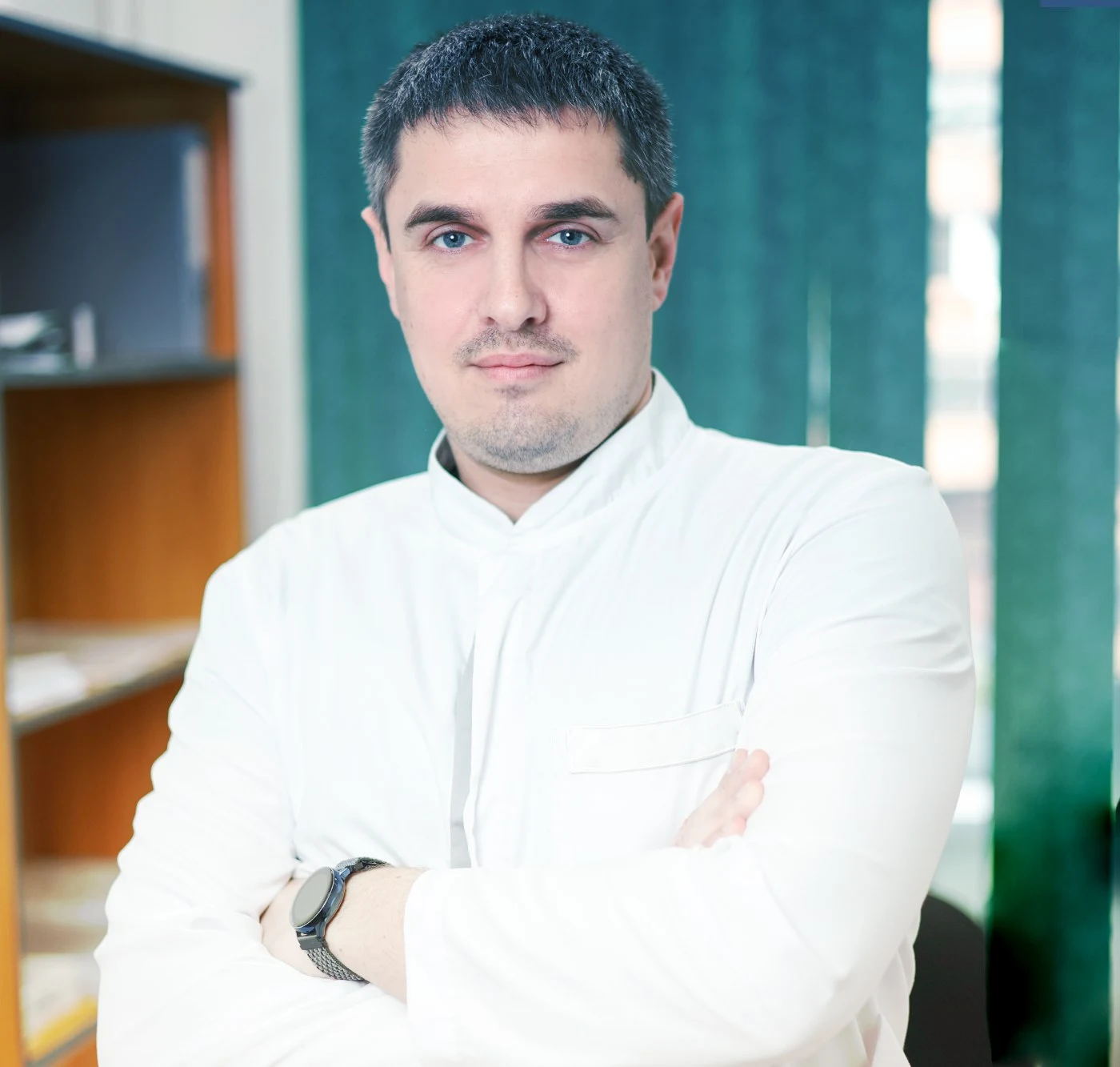 врач в белом халате скрестил руки на груди
